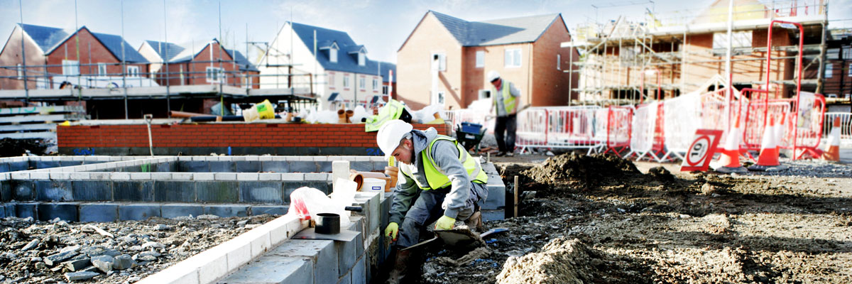 Builders working on residential housing building site